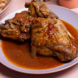 Pedaços de galinha guisada em molho, num prato